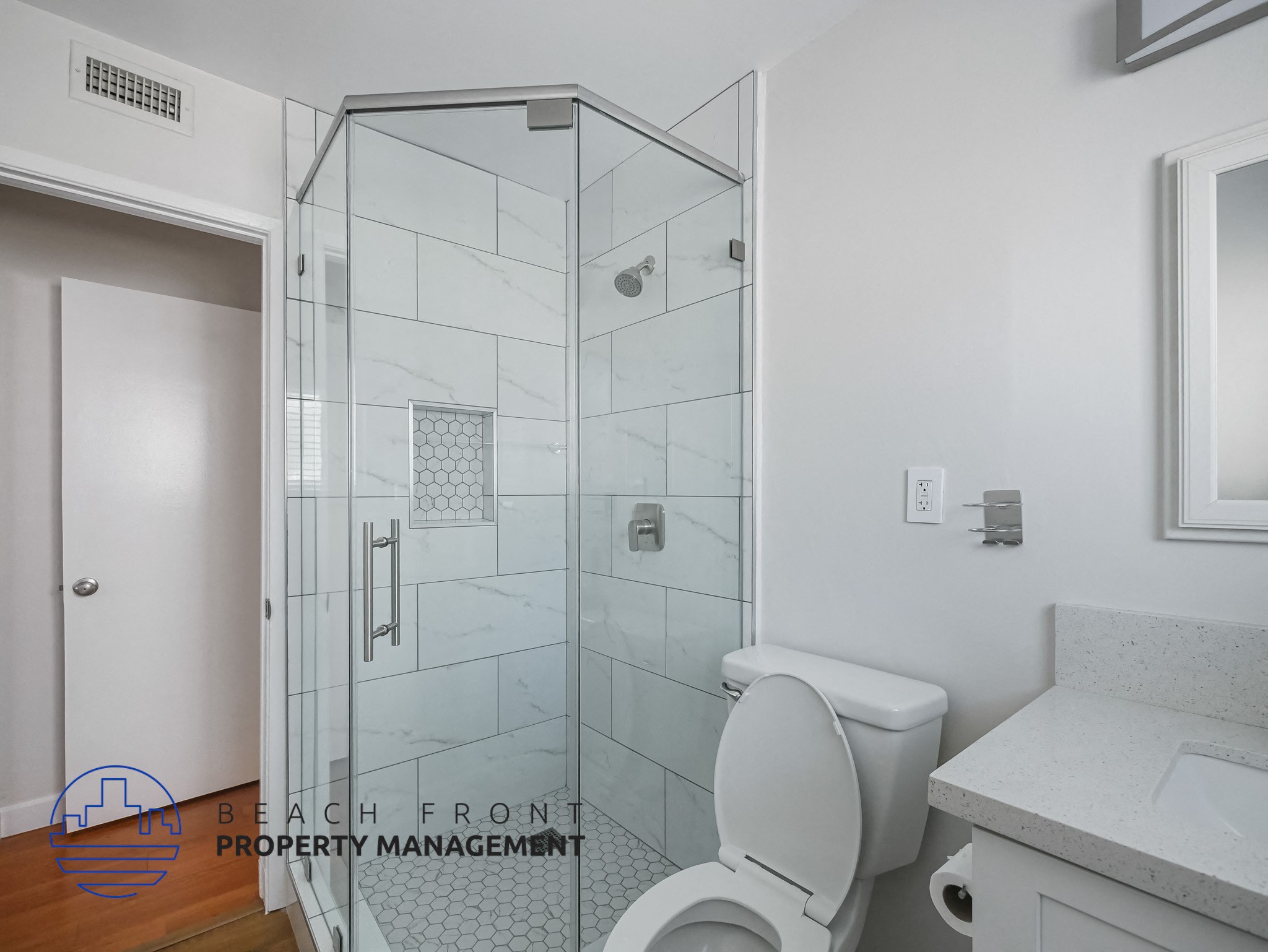A white toilet in a bathroom with a walk-in shower.